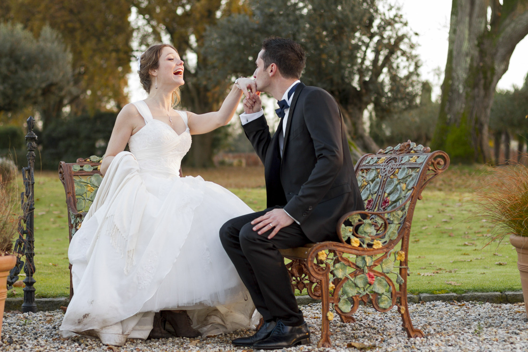 couple de jeunes mariés souriants dans les jardins du domaine du chateau Pape-Clément à Pessac en Gironde sous l'oeil du photographe de mariage à Bordeaux Sébastien Huruguen